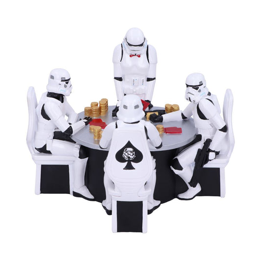 Four Stormtrooper figurines sit at a round table playing poker, surrounded by gold chips and red cards. One Stormtrooper stands wearing a red bow tie. Chairs have a spade design.