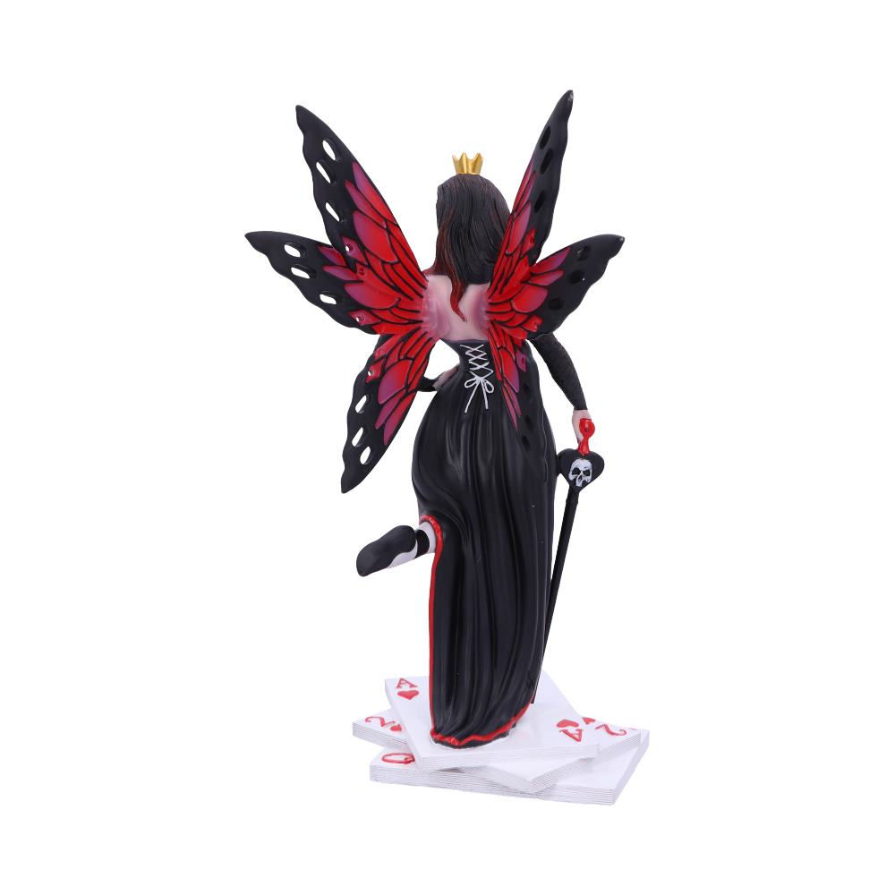 A fairy statue, with red and black wings and a crown, stands on a pile of playing cards while holding a skull staff.