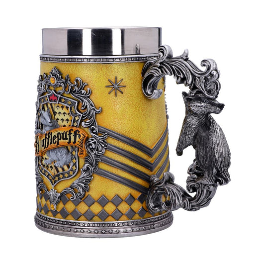 A decorative, yellow Hufflepuff-themed stein features an ornate badger handle and intricate emblem. The emblem showcases a badger and reads "Hufflepuff," with medieval-inspired designs set in a silver and gold color scheme.