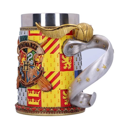 A decorative mug displays a detailed Hogwarts crest and house emblems, featuring a curving handle resembling a scroll adorned with stars, and a golden flying ball attached.