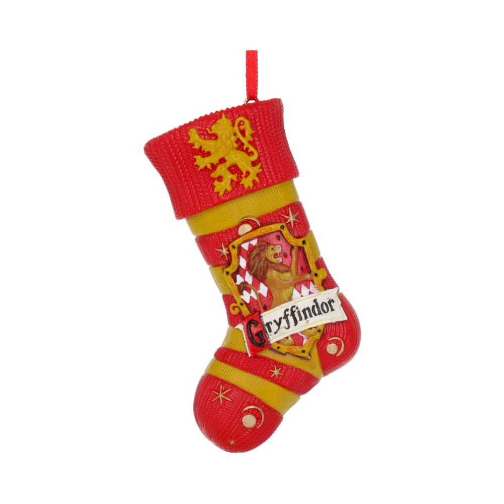 A red and yellow Christmas stocking ornament features a lion emblem and the word "Gryffindor," depicting the Harry Potter house. The background is plain, highlighting the ornament's design.