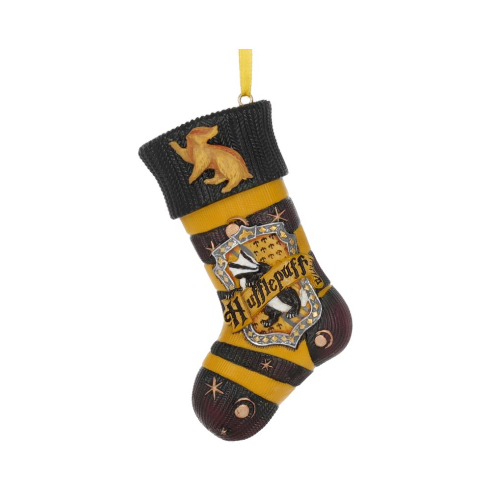 A decorative stocking hangs against a white background. It features a badger and the text "Hufflepuff" with house symbols. The stocking is predominantly yellow and black, with a textured surface.