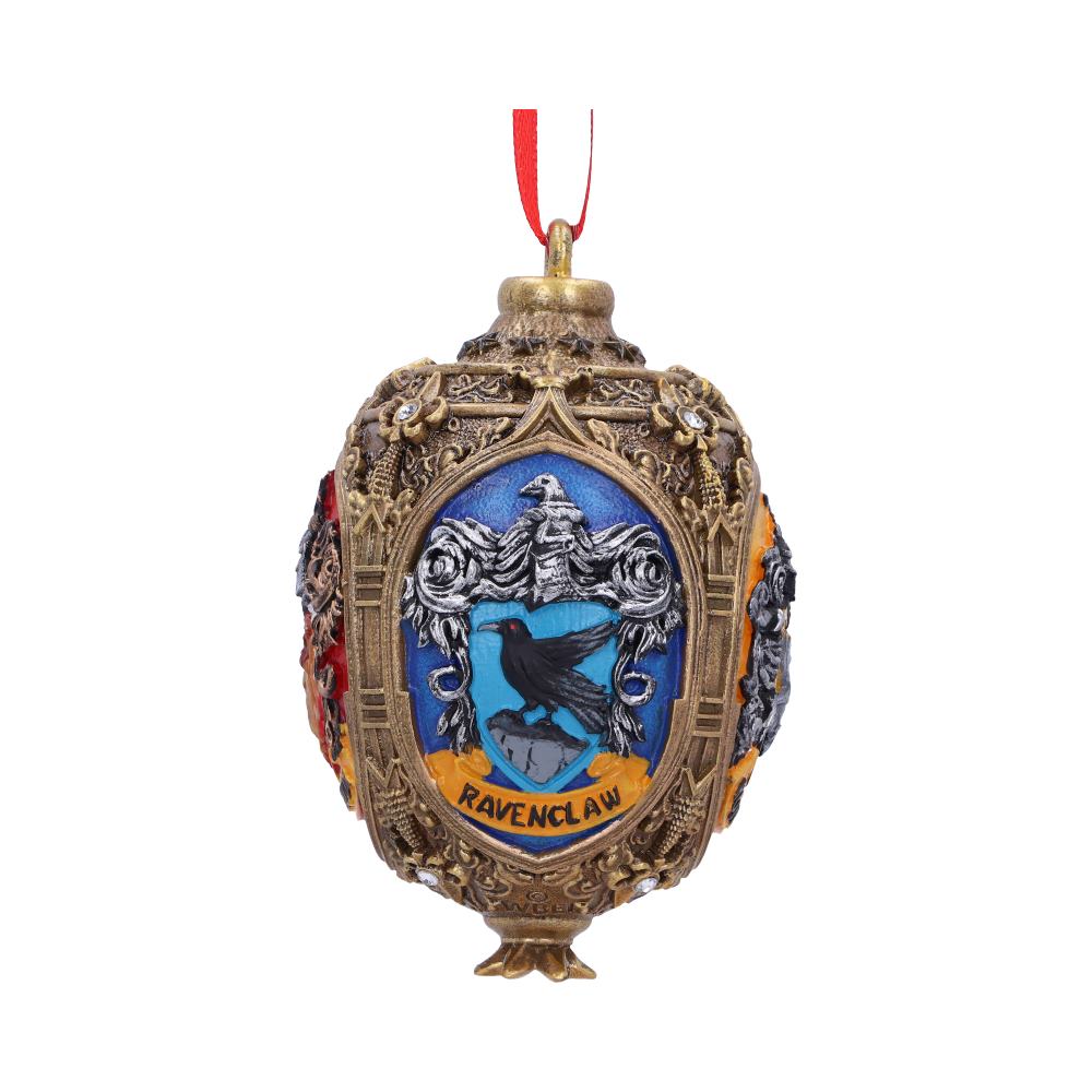 An ornate gold ornament featuring the Ravenclaw crest, displaying a black raven on blue background, hangs from a red ribbon. Text reads "Ravenclaw." Intricate patterns adorn the surface.