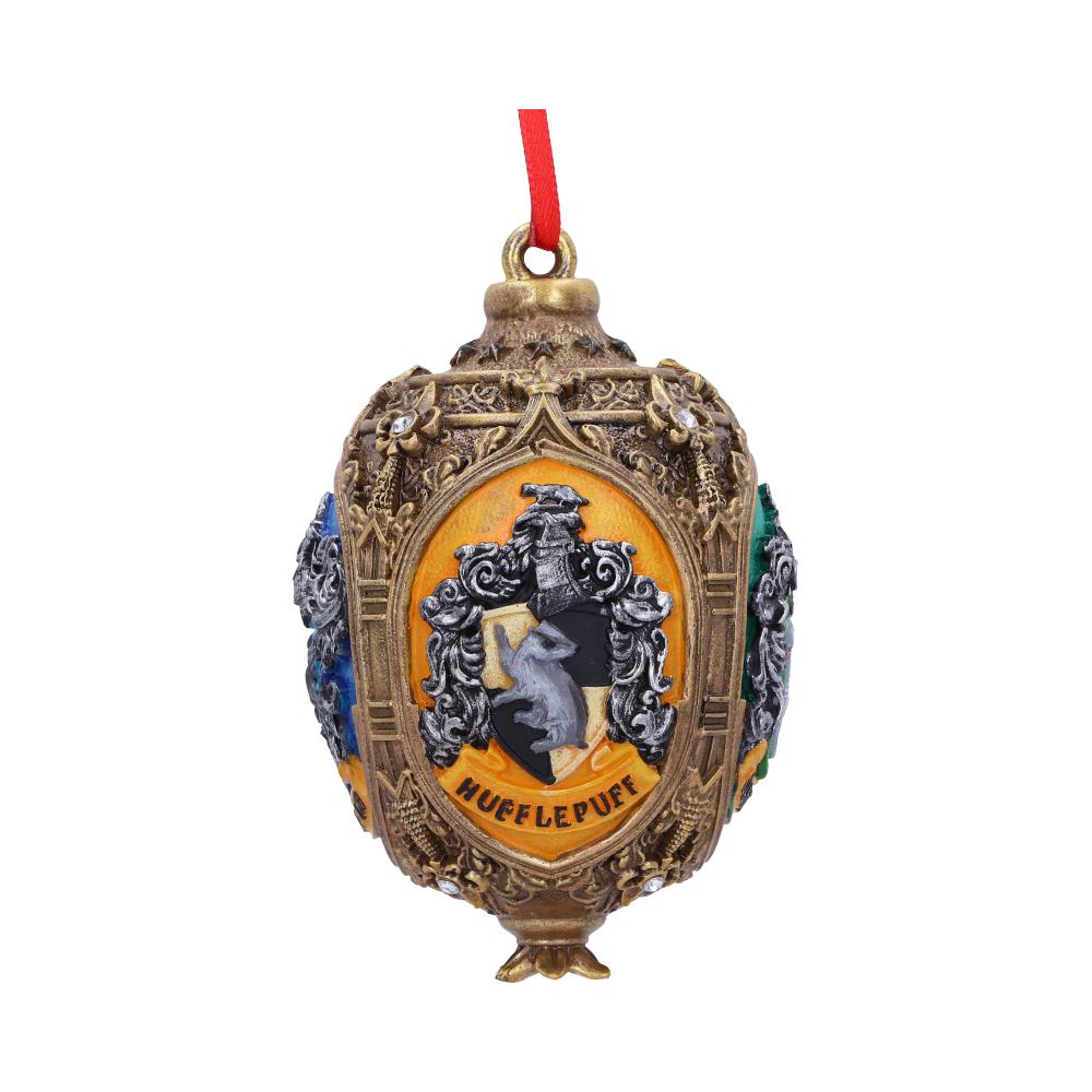 An ornate, golden ornament features the "Hufflepuff" crest with a badger emblem, adorned with red ribbon for hanging, set against a plain white background.