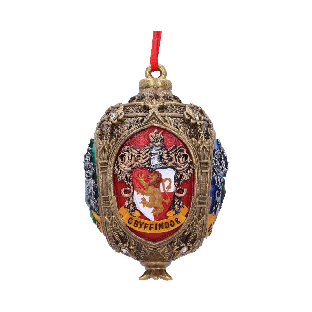 Ornament hangs with a red ribbon, displaying an ornate crest featuring a lion and the word "GRYFFINDOR" on a red shield, surrounded by intricate designs.