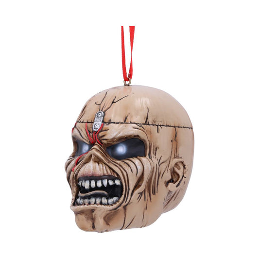 A menacing skull ornament with exaggerated features and red markings hangs by a red ribbon. It has black, hollow eyes and snarling teeth, set against a plain white background.