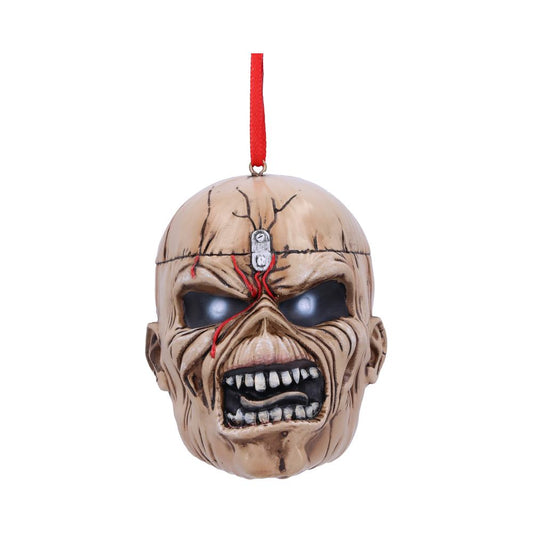 A menacing skull ornament with deep-set eyes and sharp teeth hangs from a red string. The cracked, weathered surface suggests age or wear, set against a plain white background.