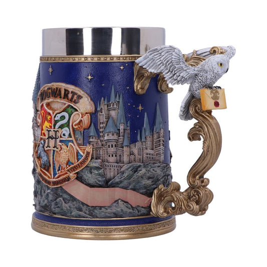 A decorative stein features a detailed Hogwarts castle scene with a gold and blue color scheme. An owl perched on the ornate handle holds a letter. Text: "HOGWARTS".