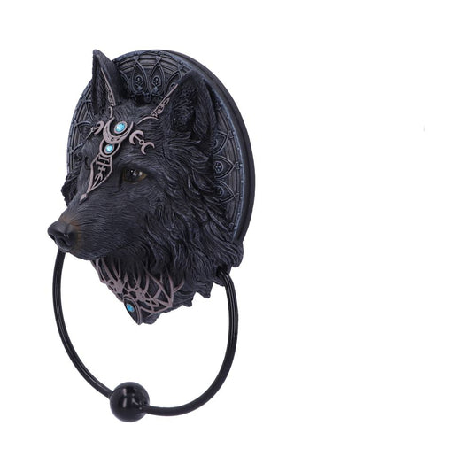 A wolf's head-shaped door knocker, featuring intricate designs and blue gems, is mounted against a patterned circular backdrop within a minimalistic white setting.
