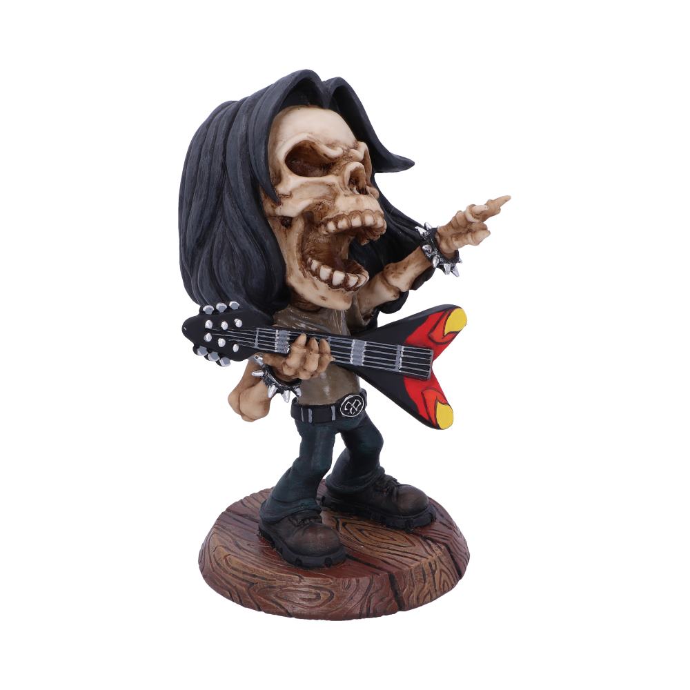 A skeleton figurine with black hair plays an electric guitar, striking a rockstar pose. The figure stands on a wood-grained base against a white background.
