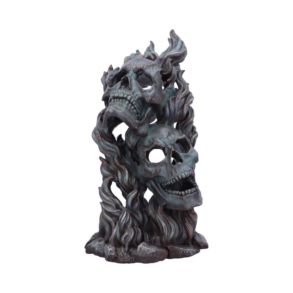 A sculpture of two intertwined skulls emerges from a flowing mass resembling flames, suggesting a dynamic and intense design. The piece has a dark, weathered metallic finish.