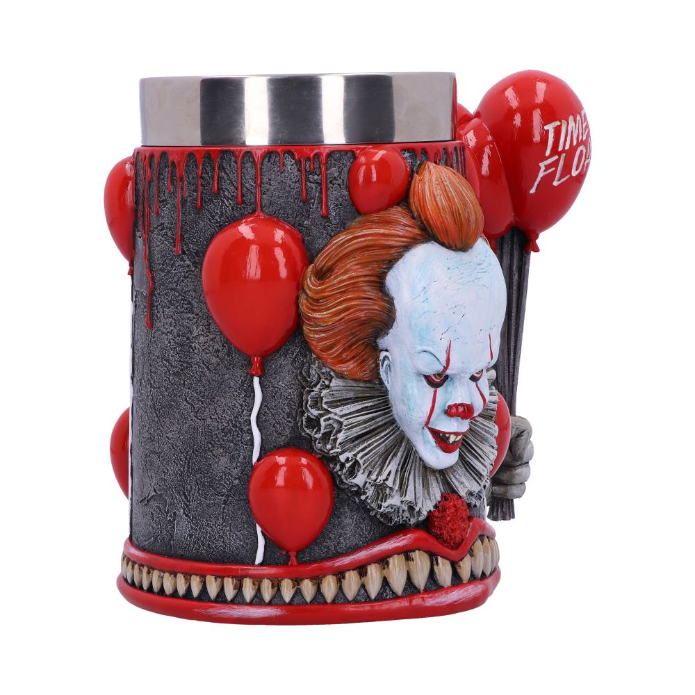 A cylindrical mug, featuring a Pennywise the Clown design, is shown. It has red balloons that say "TIME FLO," sharp teeth at the bottom, and a silver top with blood-like streaks.