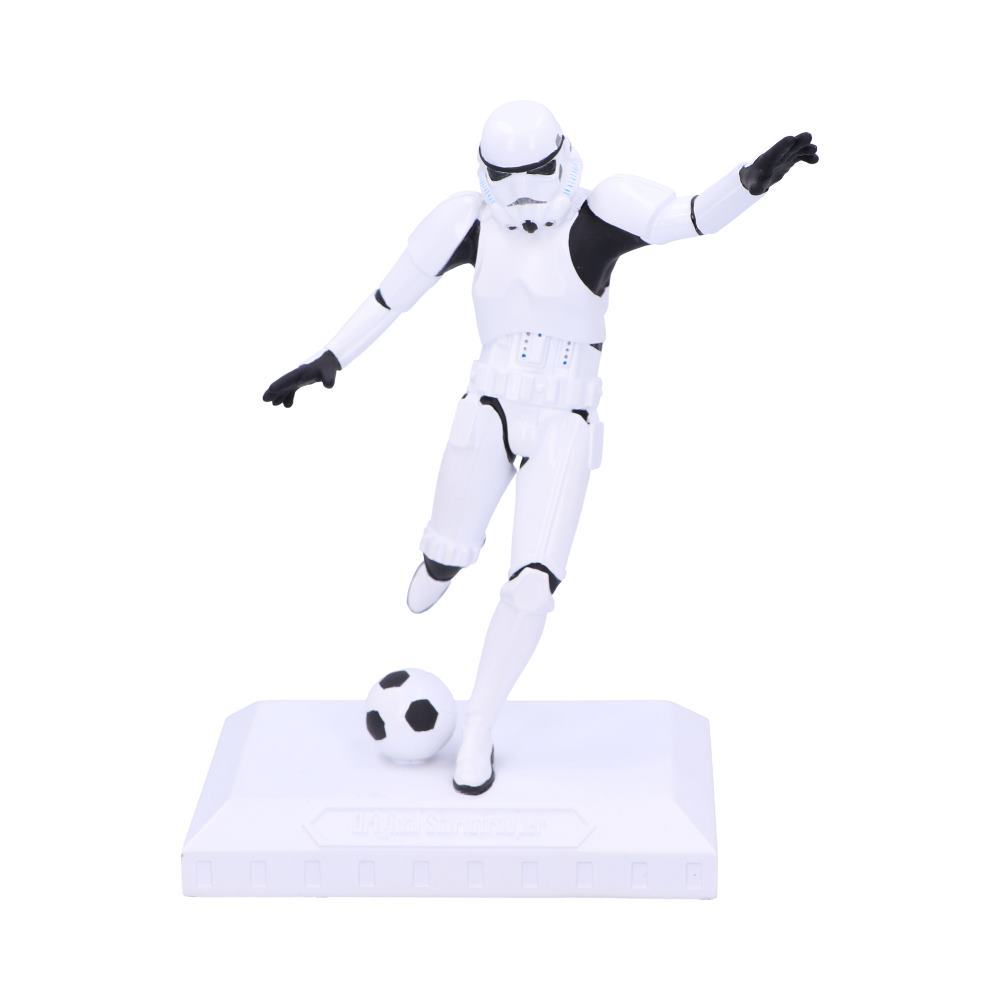 A white-armored figure kicks a soccer ball, balancing on one foot, displayed on a rectangular white base. The setting is minimal, emphasizing the figure's dynamic pose.