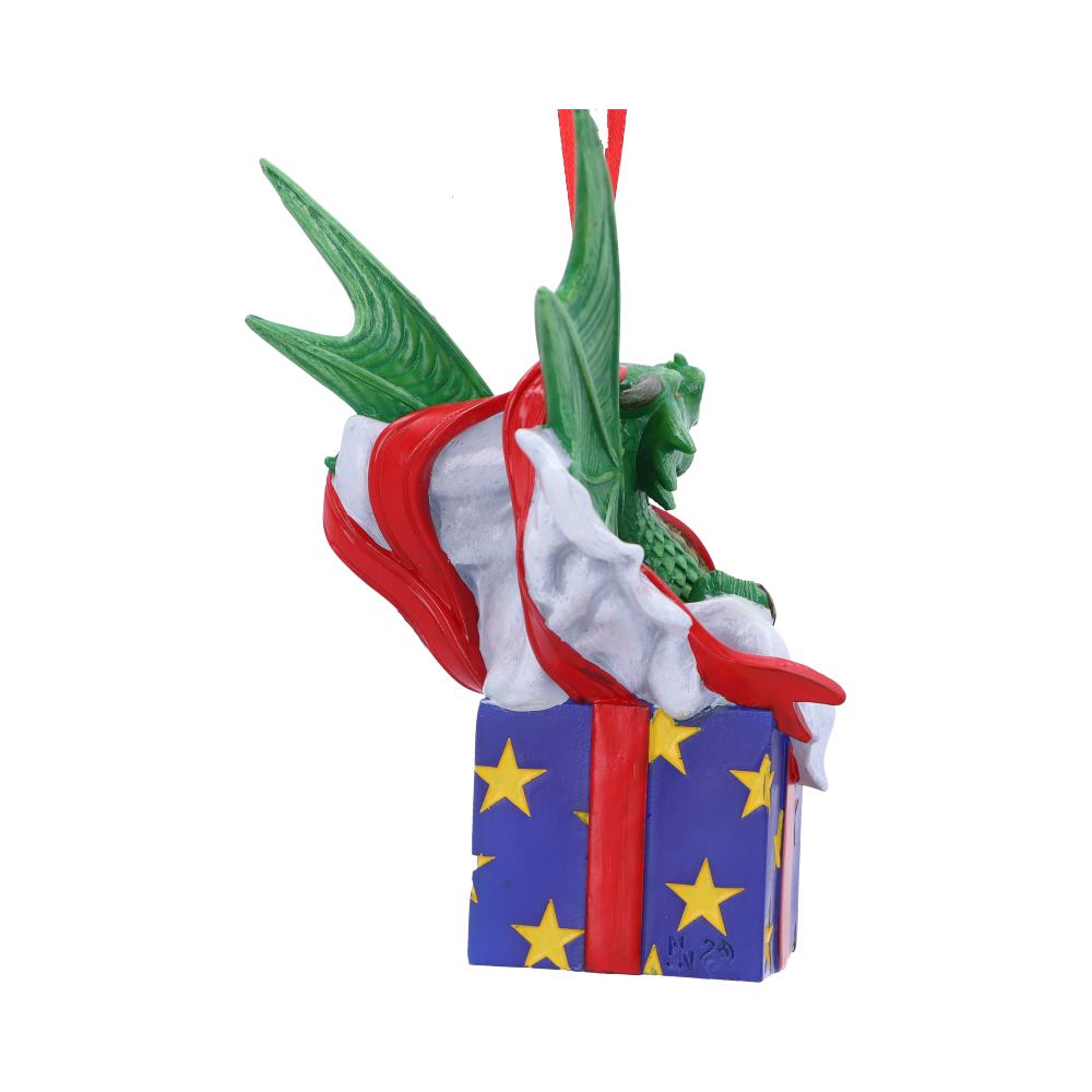 Green creature emerging from a blue gift box decorated with yellow stars, wrapped in a red and white cloth. The backdrop is plain white, highlighting the whimsical design.