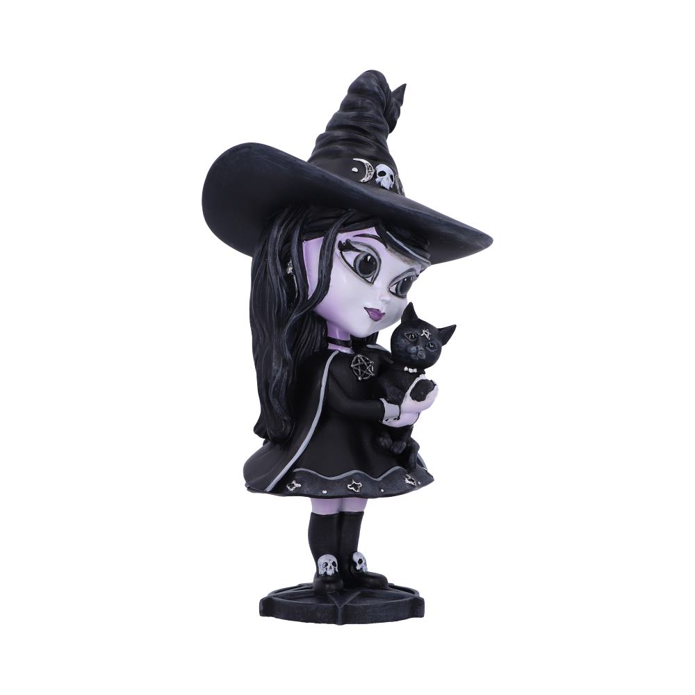 A stylized figurine of a young witch holds a black cat. She wears a wide-brimmed hat and a black dress decorated with skulls and stars, against a plain background.