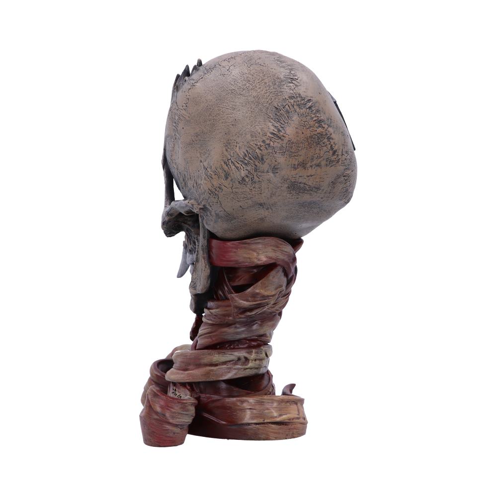 A stylized bust of a character with a large, textured head and wrapped neck, facing sideways. The surface has a weathered, stone-like appearance, set against a plain white background.