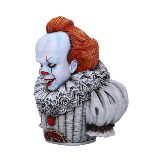 A bust of Pennywise, the clown, has white skin, red hair, and red lips; a frilly white collar surrounds his neck. The word “PENNYWISE” is written on a plaque on the base.
