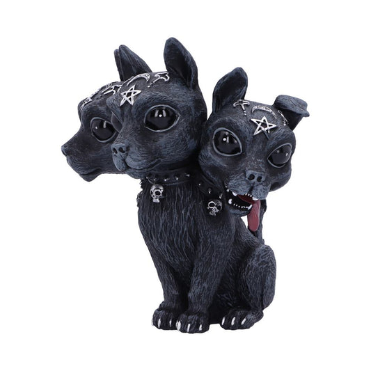 A black, three-headed dog statuette sits, facing forward, in a white space. The dog's heads are decorated with pentagrams and moons, and the collar has skull charms. One head has its tongue out.