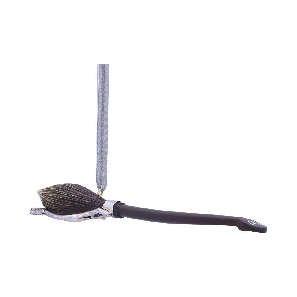 A paintbrush with dark bristles and a black handle hangs vertically from a silver hook against a white background.