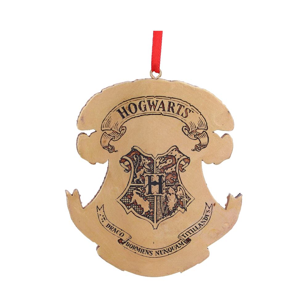 A brown, shield-shaped ornament displays "Hogwarts" and a detailed crest featuring an 'H', with a red hanging ribbon. Text below reads "Draco Dormiens Nunquam Titillandus."