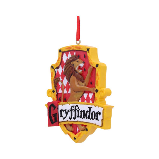 A decorative ornament features a lion on a red and white shield, with text "Gryffindor" in bold letters below. It is hanging by a red ribbon.