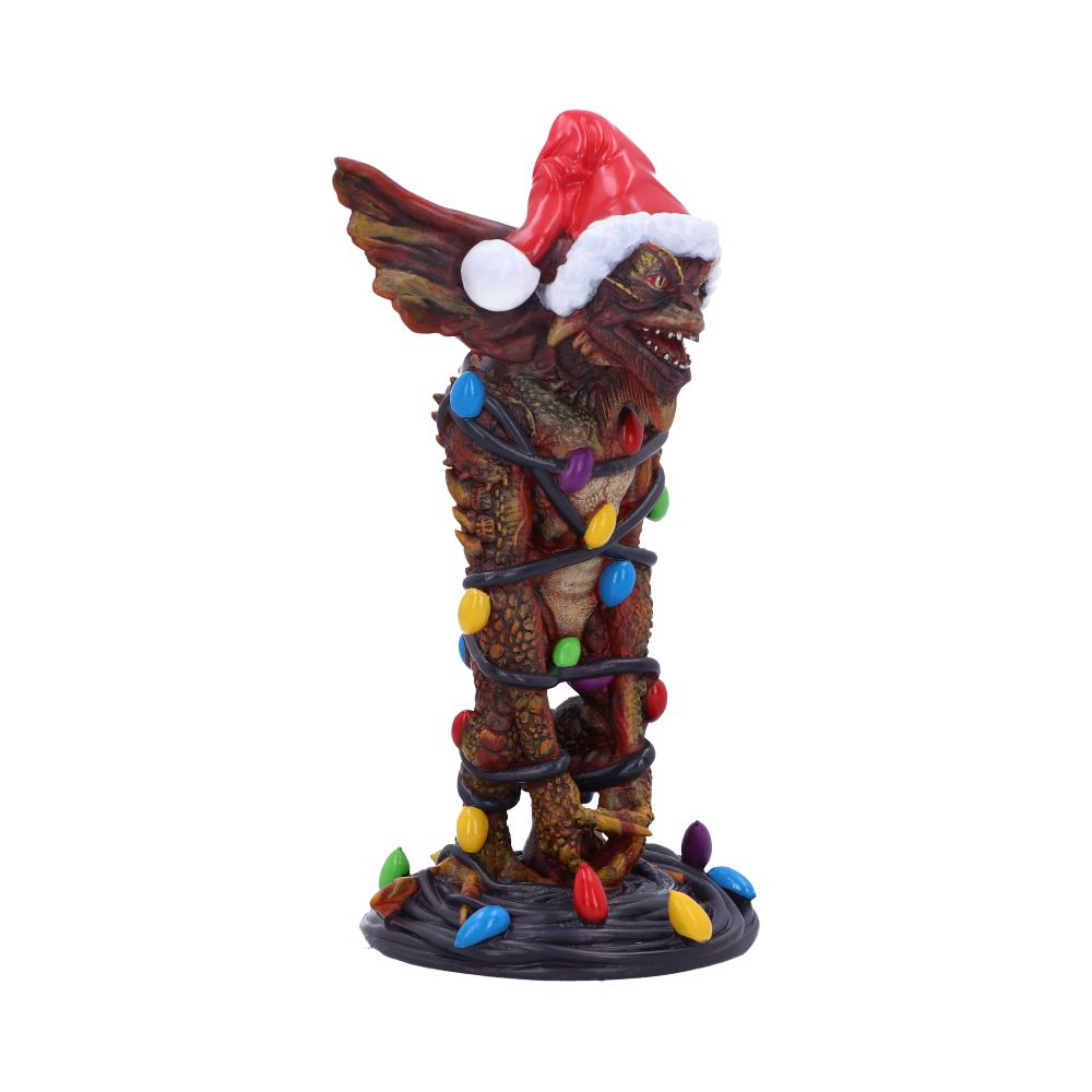 A creature figurine wrapped in colorful holiday lights stands on a circular base, wearing a red Santa hat, set against a plain white background.