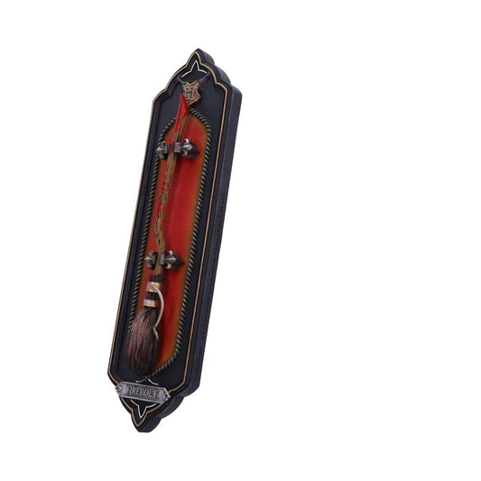 A miniature broomstick labeled "Firebolt" is mounted on a decorative, vertical black and red plaque with ornate details, resembling a display piece or collectible item.