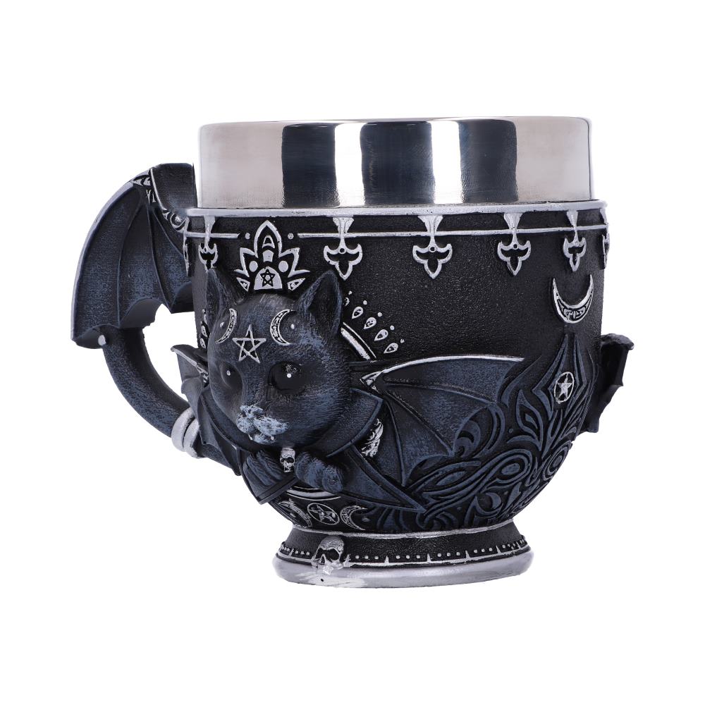 A black, ornate mug with a silver interior displays a bat-winged cat wearing a cape. Stars, crescent moons, and other symbols decorate the mug's exterior, set against a white background.