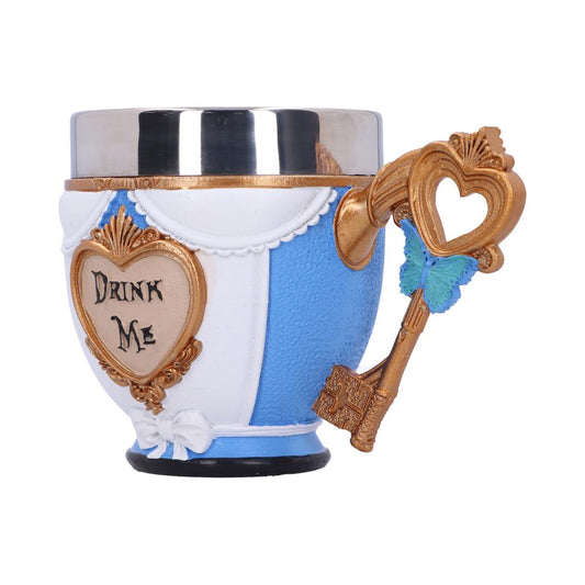A "Drink Me" teacup, styled after Alice in Wonderland, sits against a white backdrop. A decorative, golden key with a heart-shaped head acts as the handle with a blue butterfly on it. Text on the cup reads "DRINK ME".