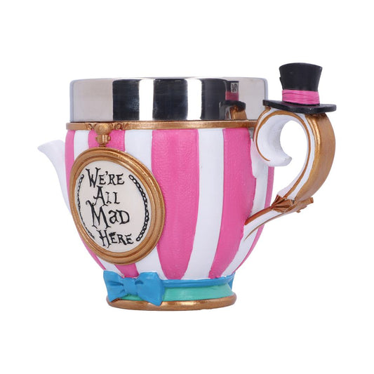 A striped teacup stands with a black top hat on its handle and a round label with the text "We're All Mad Here" attached on its side against a white background.