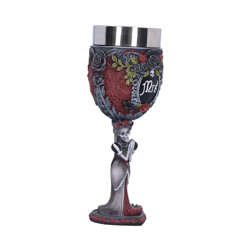 A wine goblet is decorated with roses, leaves, and skulls, as well as the word "Mrs," while a skeletal bride forms the stem and base against a white background.