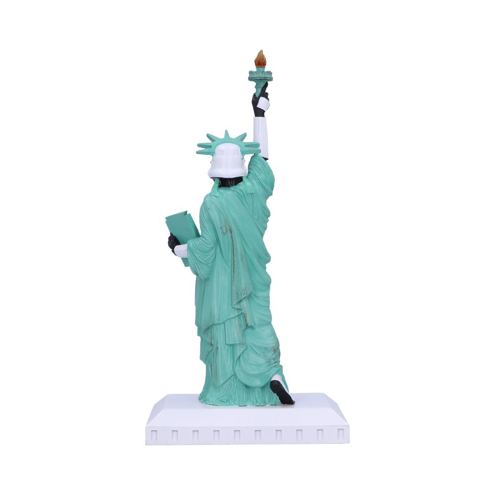 A small, stylized Statue of Liberty figurine features a robotic aesthetic, holding a torch and tablet. It stands on a simple square base, set against a plain white background.