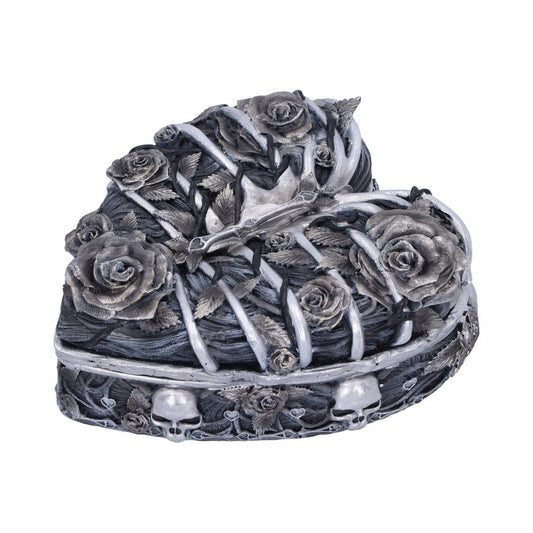 Heart-shaped decorative box features entwined roses and thorny vines, accented with small skull motifs. The intricate design is textured with silver and dark tones, giving it a gothic appearance.