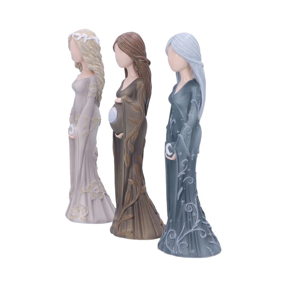 Three faceless, robed figurines stand side by side, each with unique designs: beige with flowers, brown with leaves holding a belly, and blue with celestial patterns, on a plain background.