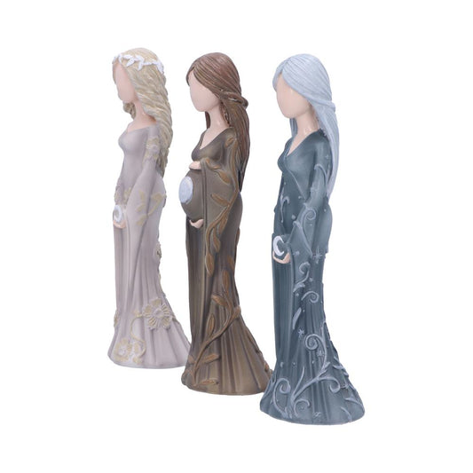 Three faceless, robed figurines stand side by side, each with unique designs: beige with flowers, brown with leaves holding a belly, and blue with celestial patterns, on a plain background.