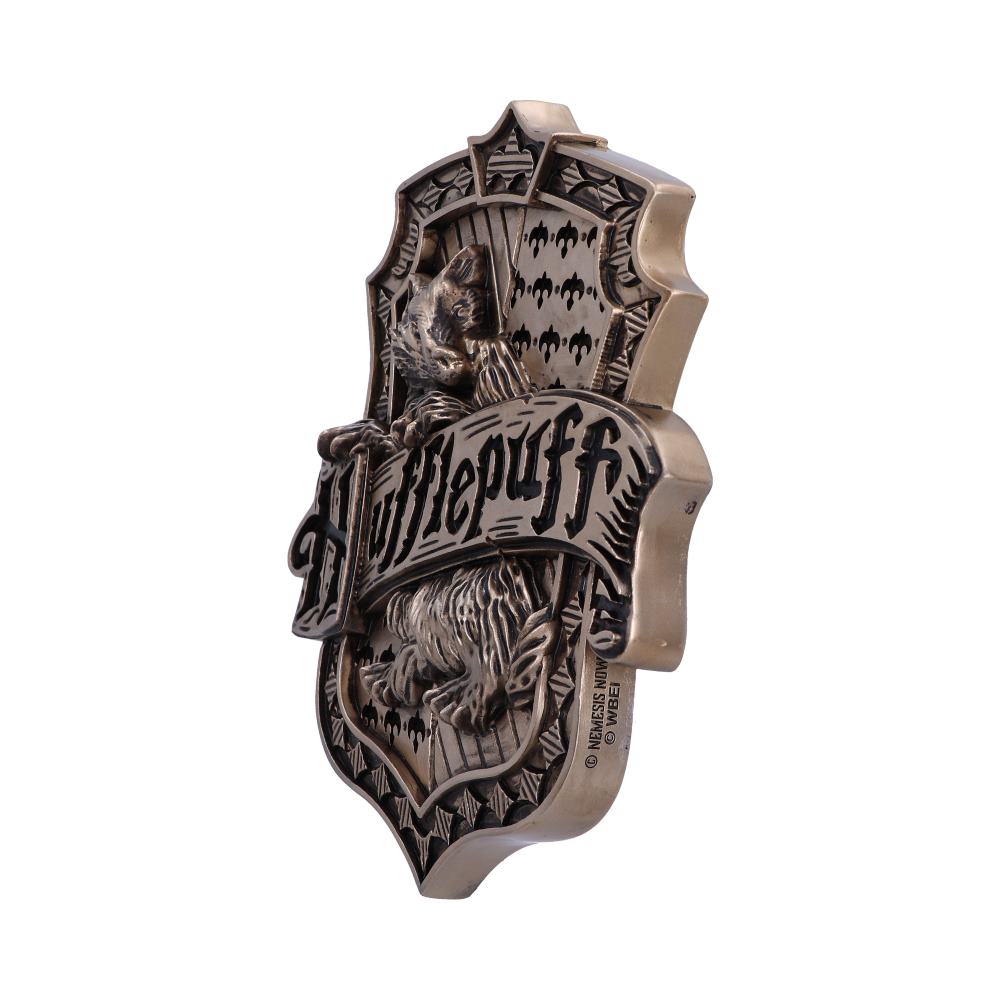 Bronze emblem with a badger, displaying the text "Hufflepuff," featuring ornate patterns in the background. The design suggests affiliation with a fantasy-themed house, possibly from a fictional setting.