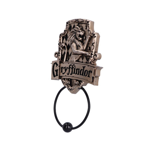 An ornate door knocker features a lion relief above a hanging ring. The text reads "Gryffindor" on a banner. The design is intricate with a bronze-like finish.