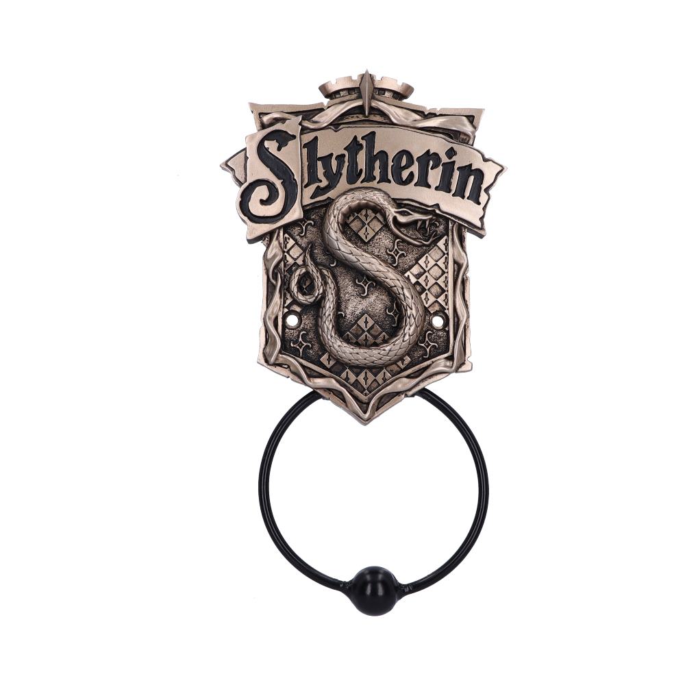 A metal door knocker features a coiled snake forming an "S" shape on a shield with "Slytherin" inscribed above. The knocker handle is black, set against a plain white background.