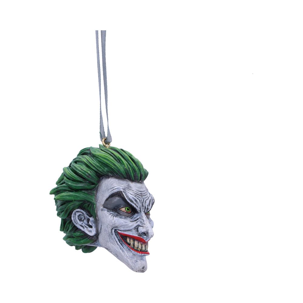 A detailed head ornament features a grinning face with green hair, hanging by a ribbon. The ornament is set against a plain, white background.