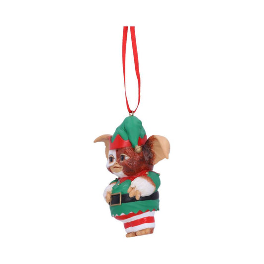 A small, elf-like creature with large ears and a green-red outfit hangs from a red string, resembling a decorative ornament against a plain background.