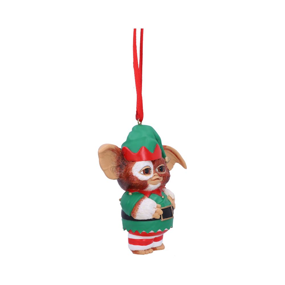 A small creature-themed ornament, dressed in green and red elf attire, hangs from a red string. It features large ears and a whimsical expression, set against a plain white background.