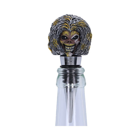 A bottle stopper with a detailed, menacing face featuring wild hair and a wide grin, plugs into the top of a glass bottle against a white background.