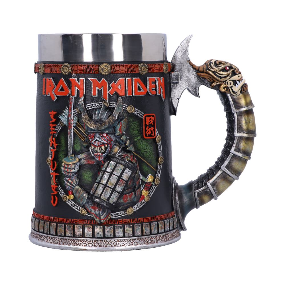 The object is a metal mug decorated with "IRON MAIDEN" text and a samurai warrior illustration. The handle resembles a dragon tail. The mug is detailed with intricate patterns, emphasizing a medieval theme.
