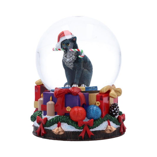 A black cat sits in a snow globe, wearing a Santa hat and holding candy canes. The base has wrapped gifts, candles, and ornaments decorated with pine garland.