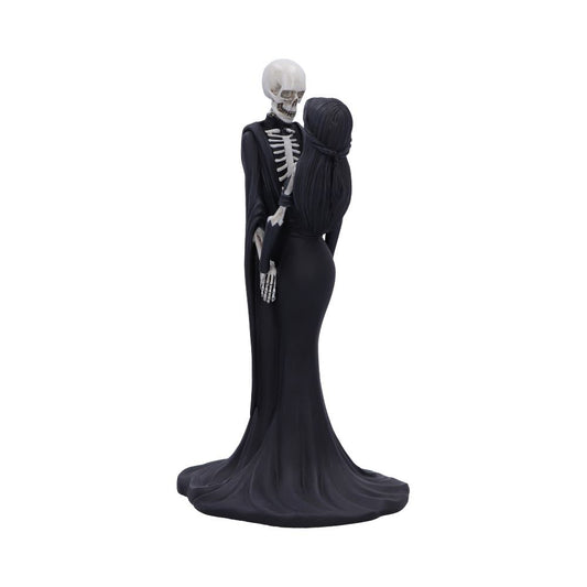 A figurine depicts a white skeleton and a woman with long black hair, both wearing black, long gowns. The skeleton is holding the woman around the waist while facing her on a white background.