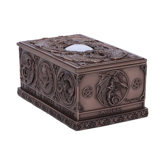 A bronze-colored rectangular box features intricate dragon engravings and pentagrams. It displays the words: "BELTANE," "OSTARA," "IMBOLC," "YULE," and "VERONESE," suggesting a mystical, ceremonial context.