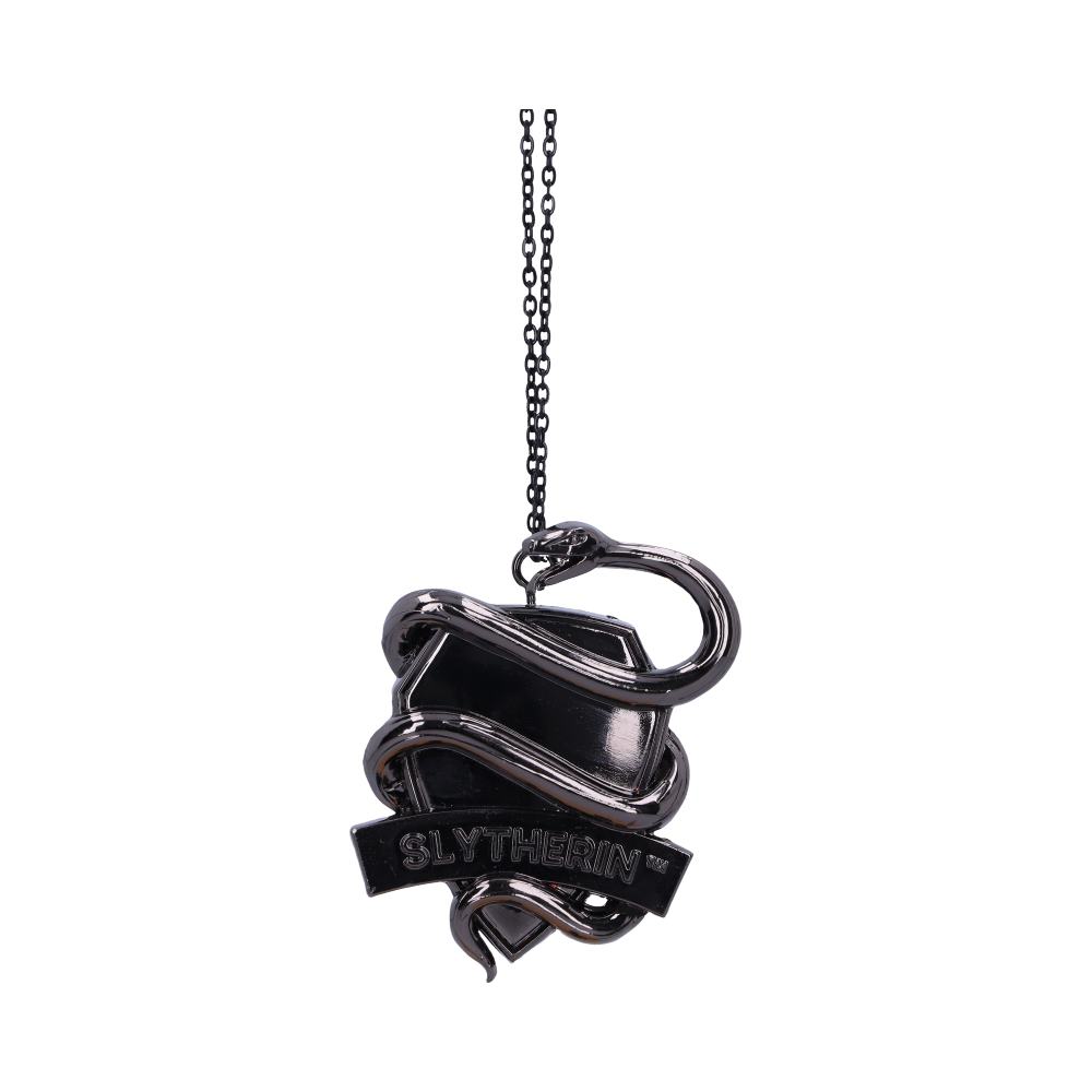 A silver necklace pendant features a snake coiling around a shield, with "SLYTHERIN" inscribed on a banner beneath. The pendant hangs by a chain against a white background.