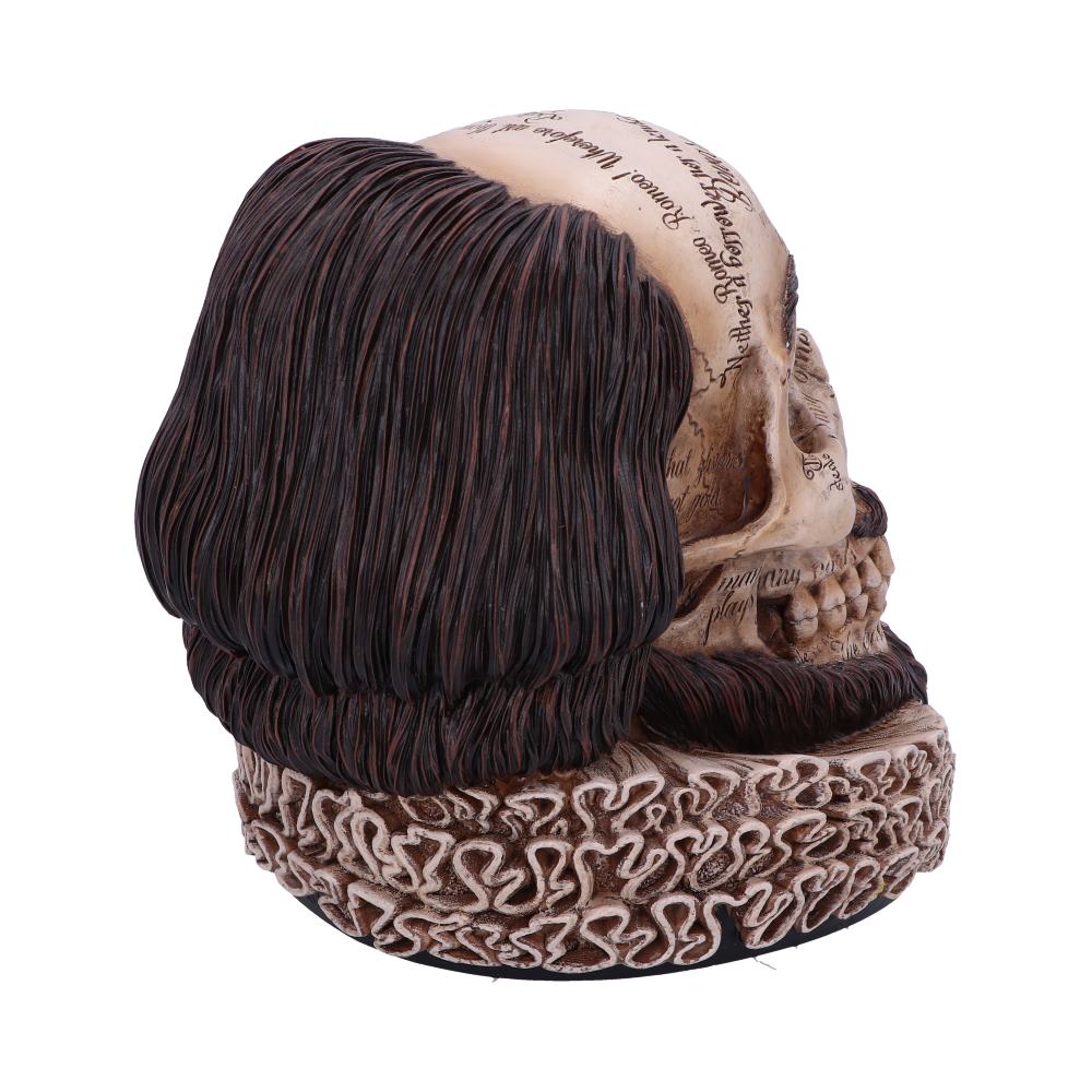 A skull sculpture with detailed hair and ruff collar, inscribed with cursive text on the skull cap, resembles a historical or theatrical theme in a plain setting.