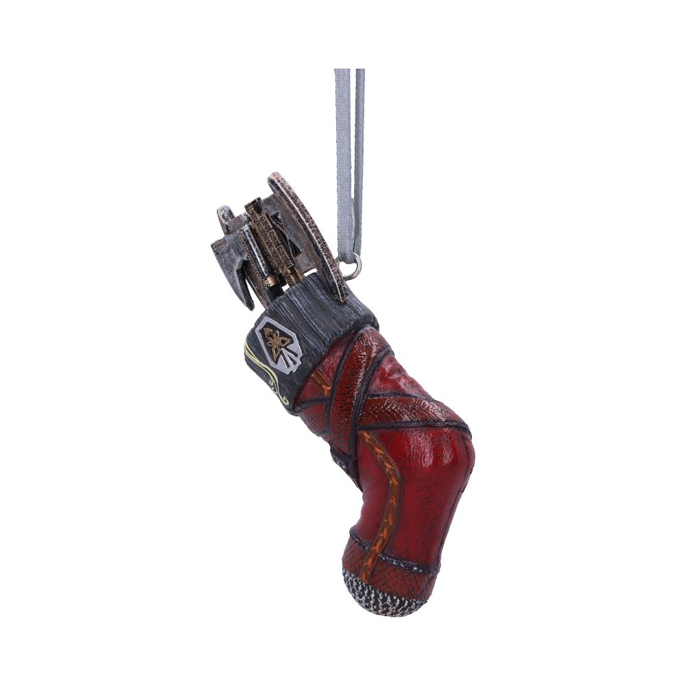 A detailed, red mechanical hand ornament features intricate metallic components and a hanging loop. It has a decorative patch with a star symbol and appears suspended in a neutral space.