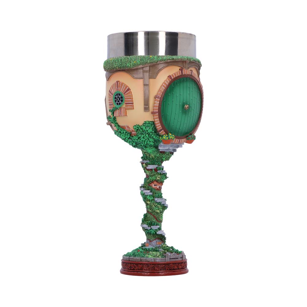 A goblet styled as a hobbit house features a round green door and detailed stone steps winding up the stem, set against a fantasy theme.